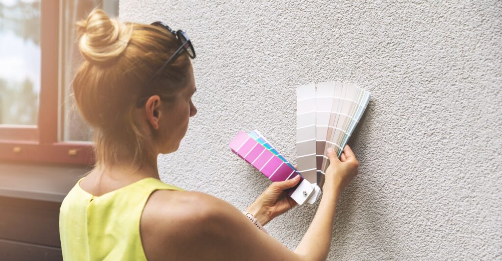 woman looking color swatches over wall