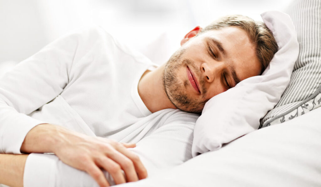 man sleeping in white mattress