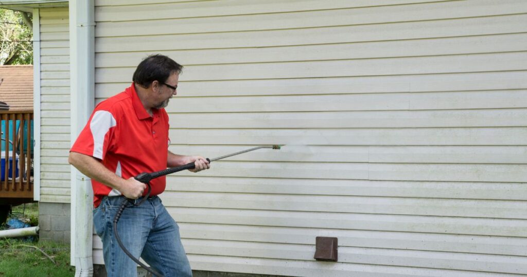man cleaning siding